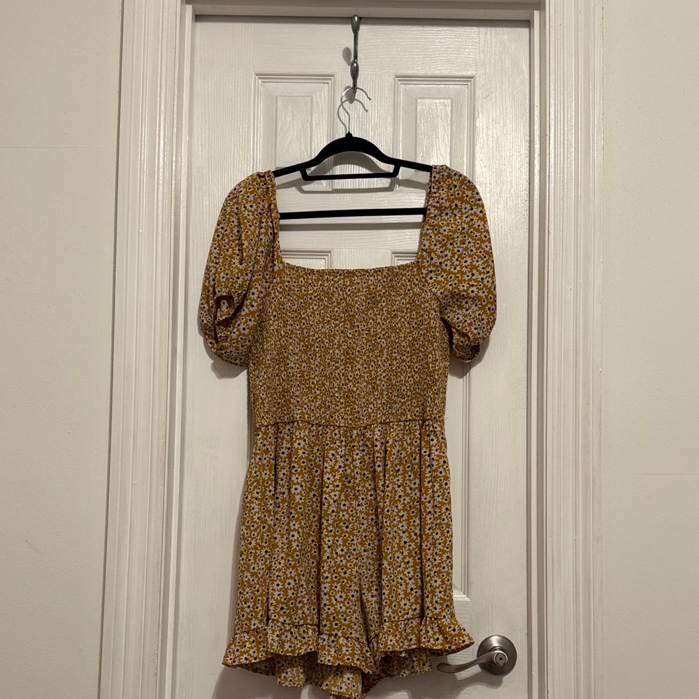 Yellow romper with white floral detail and smocked bodice and cap sleeves